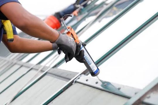 Installer running a bead of sealant along a glazing joint