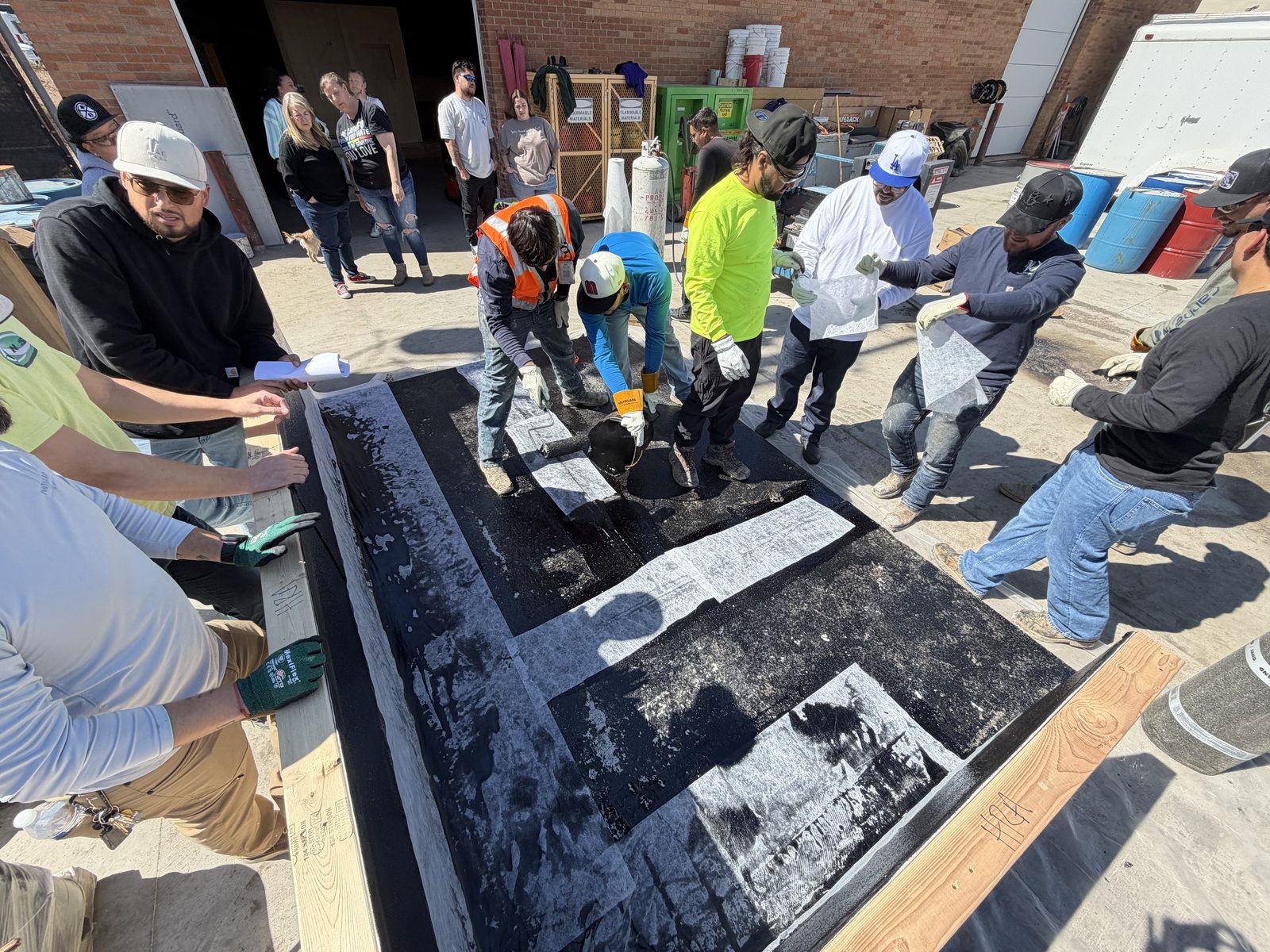 Contractors installing a waterproofing membrane during hands-on training
